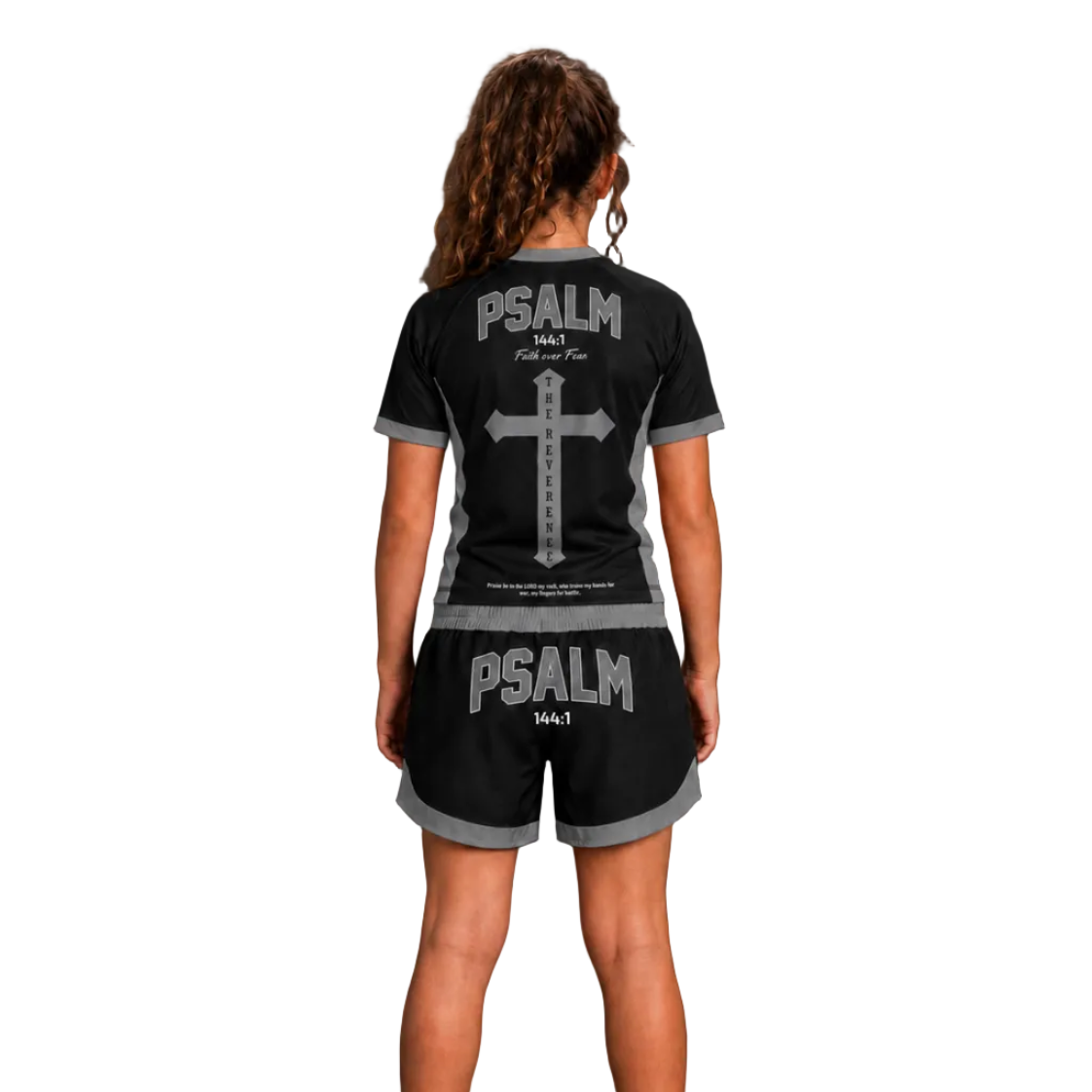 A woman stands barefoot facing away from the camera wearing a black short-sleeve pajama set with gray trim and a large gray cross and 'PSALM bed' graphic on the back. The image has 'TheReverence' branding, 'GRAY COLORWAY' text, and 'BACK' text on a dark gray studio background.