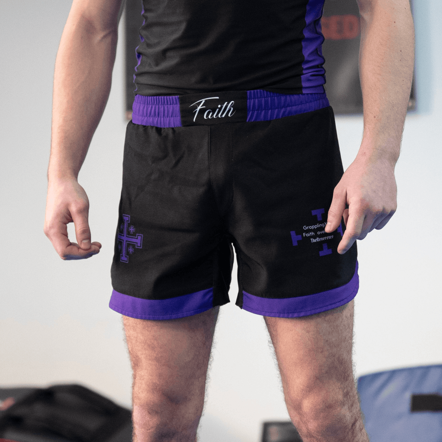 Man wearing black and purple shorts with cross designs 
