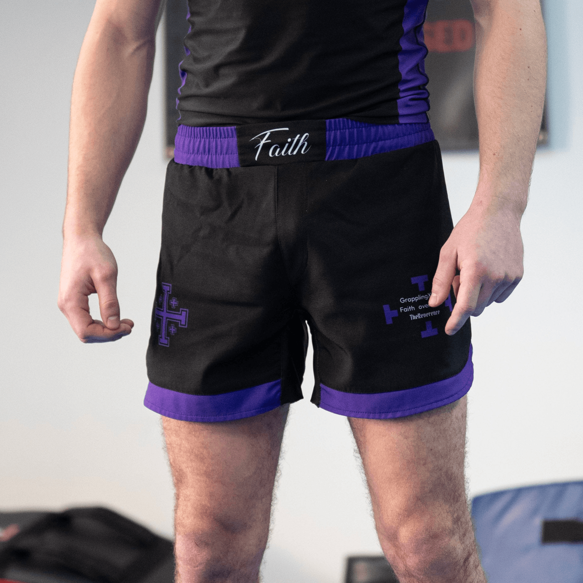 Man wearing black and purple shorts with cross designs 