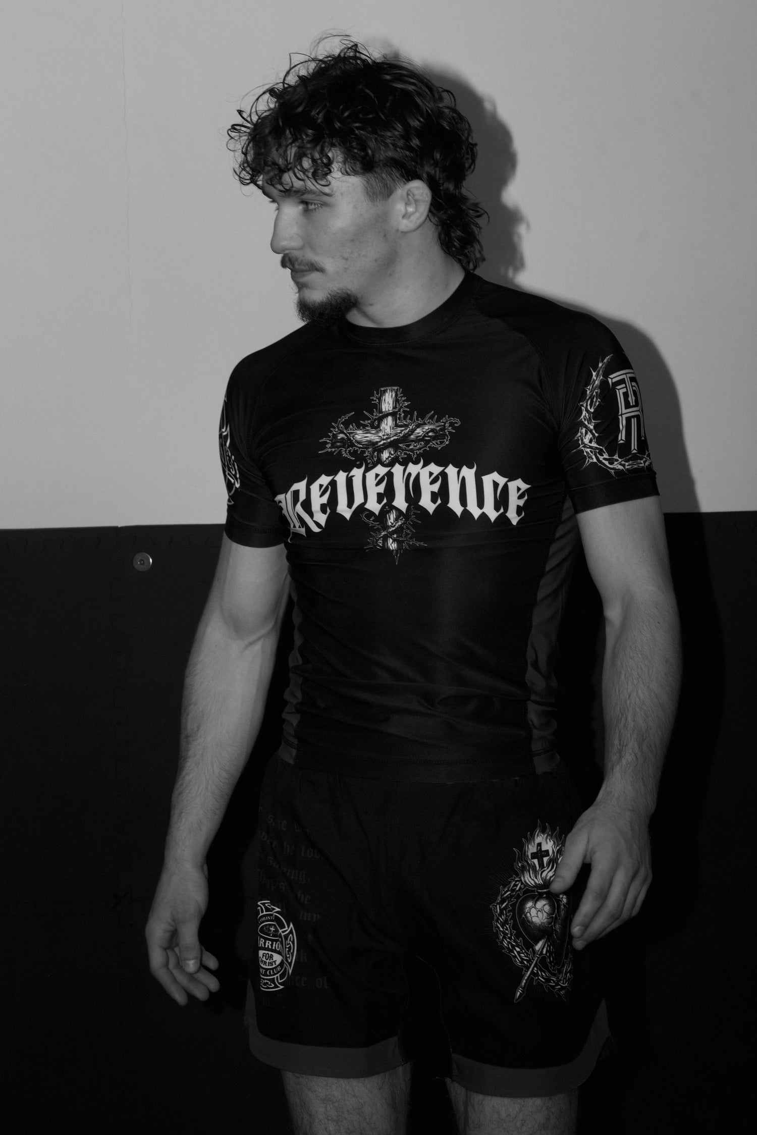 Man wearing a black 'Reverence' shirt against a plain background