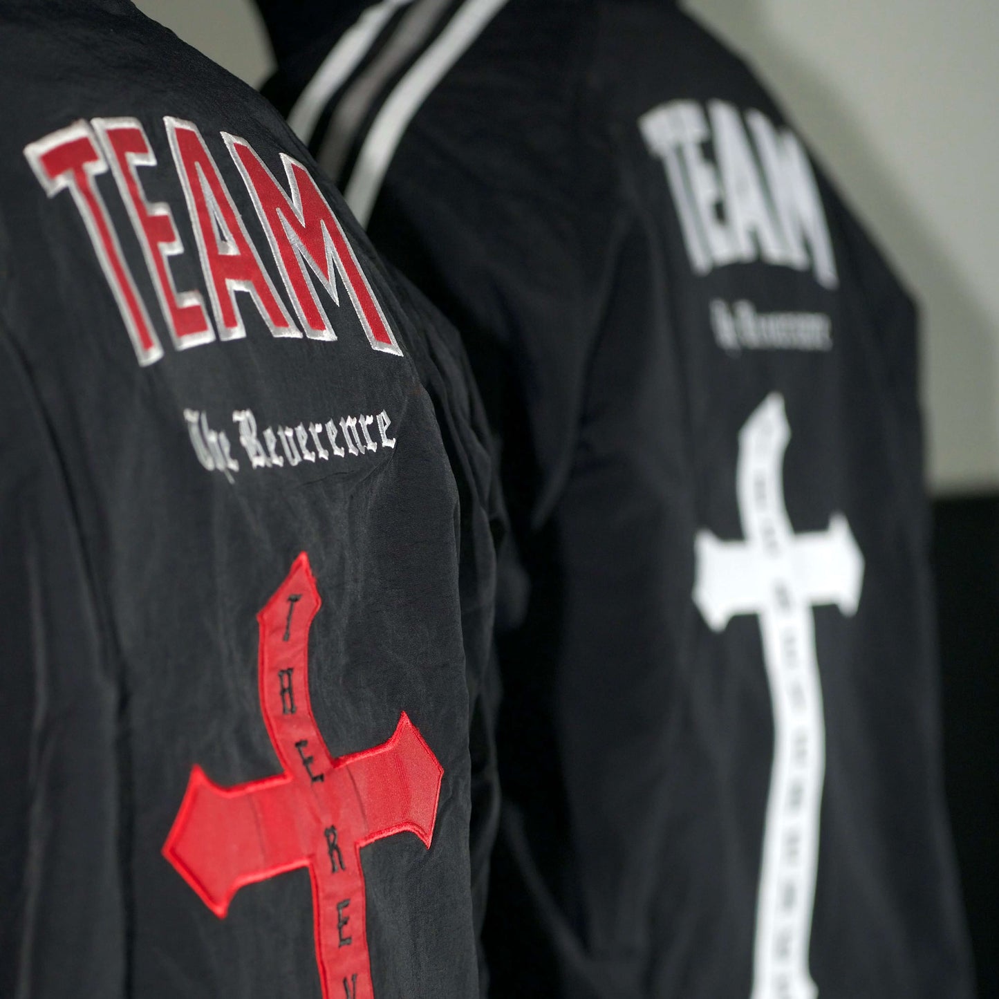Black jackets with red and white crosses and 'TEAM' text on a dark background
