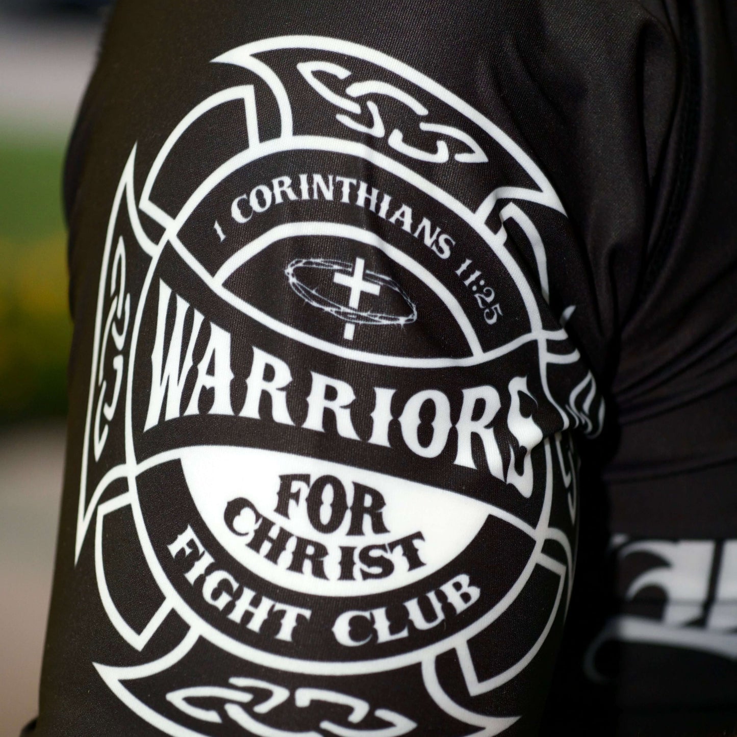 Black sleeve with white 'Warriors for Christ Fight Club' design on a blurred background