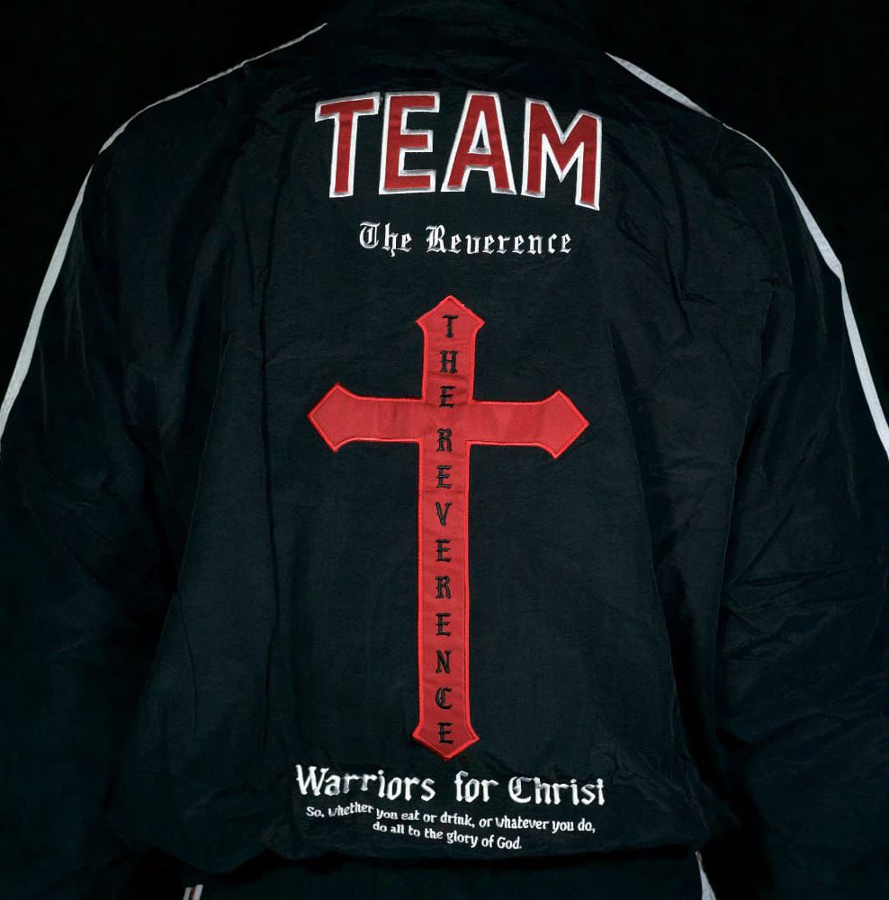 Person wearing a black jacket with red cross and text design on the back