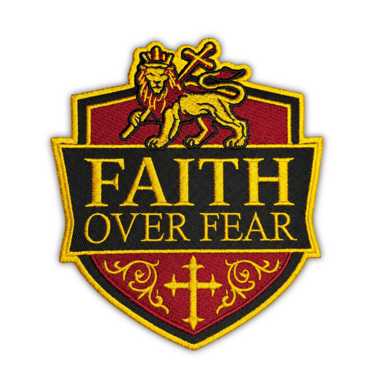 An embroidered shield-shaped patch with a gold lion and cross at the top, the words 'FAITH OVER FEAR' in gold on a black center panel, and a red lower section with a gold cross and scrollwork, shown on a plain white background.