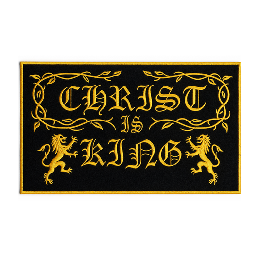 A rectangular black doormat with a gold border and the phrase 'CHRIST IS KING' in ornate gold lettering, flanked by two gold lions, shown on a plain white background.
