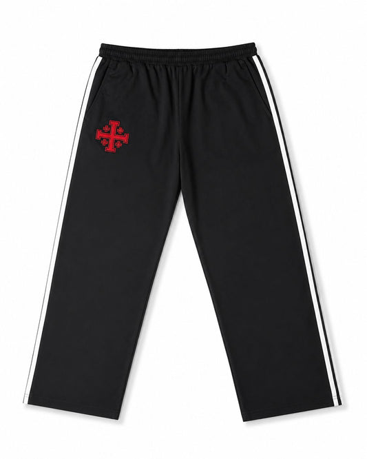 Black track pants with a red cross logo on a white background