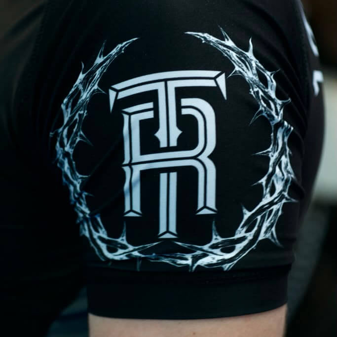 Black sleeveless top with a white logo on a blurred background