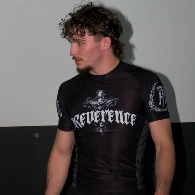 Person wearing a black 'Reverence' athletic outfit against a plain background